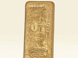 une barre d'or posée sur une surface blanche