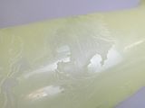un vase vert orné d'un motif, posé sur une table