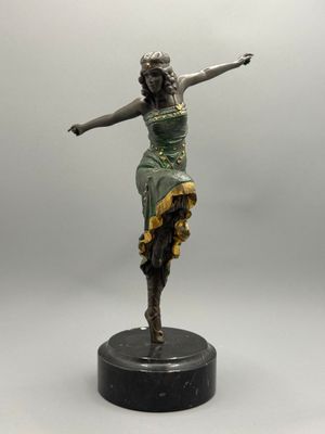 une statue représentant une femme en robe verte, posée sur un socle noir