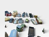 a lot of toy cars and a cell phone on a white surface