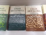 three books of the quran are lined up on a white surface