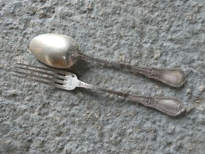 two forks and spoons on the ground next to each other