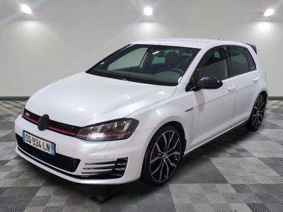 a white volkswagen golf gt with black rims parked on a checkered floor