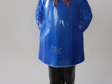 figurine représentant une femme vêtue d'un manteau bleu et d'une écharpe rouge