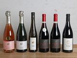 plusieurs bouteilles de vin sont alignées sur une table en bois