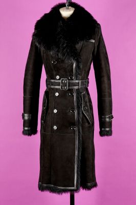un manteau noir à col de fourrure posé sur un présentoir pour mannequin