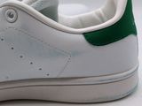 a close up of a pair of white and green sneakers