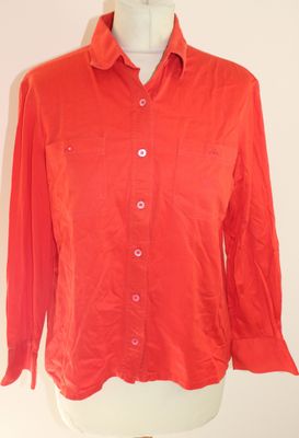 une chemise orange sur un présentoir avec un mannequin blanc