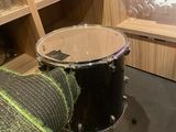 a drum in the corner of a room with wine glasses on the shelves