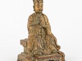 une vieille statue en bronze représentant un homme assis sur un banc