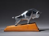 une image représentant une statue de taureau en argent posée sur un socle en bois