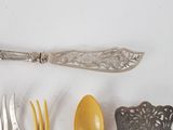 a silver spoon, fork, and spoon rest on a table