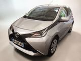 La Toyota AY est garée dans une pièce au fond blanc.