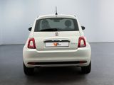 the back end of a white car in a room with a white wall