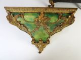 a green and gold shelf with a clock on it