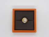an orange box with a ring inside of it on a white surface