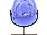 sculpture of a blue glass sphere on a black metal stand