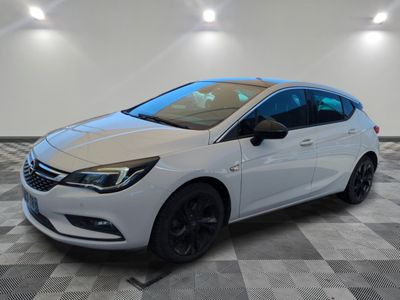a white opel parked on a checkered floor in a garage