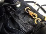 an image of a black purse with a gold buckle