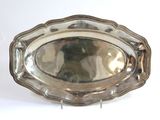 a silver tray with a silver handle on a white surface