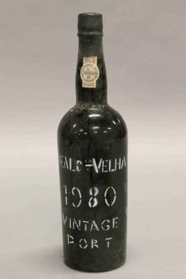 une vieille bouteille de vin posée sur une table blanche
