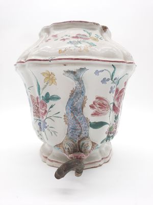 un vase orné d'un poisson, posé sur un fond blanc