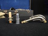 a silver pipe sitting next to a silver case