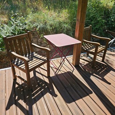 deux chaises en bois et une table sur une terrasse en bois