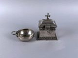 a silver plate with a small bowl and a silver spoon