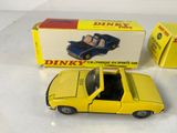 a yellow toy car sitting next to a box of dinky