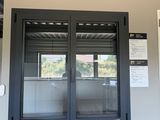 une photo d'une fenêtre noire sur un mur blanc