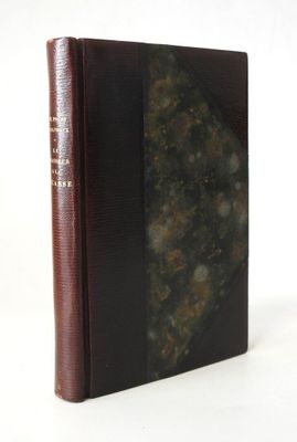 an old book with a brown cover sitting on top of a white table