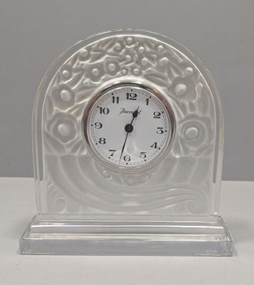 a glass clock with a white face on a table