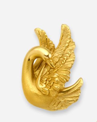 une broche en forme d'oiseau plaquée or sur fond blanc