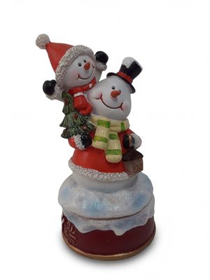 deux bonhommes de neige posés sur un gâteau