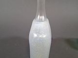 a white vase sitting on a table next to a green vase