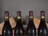 three bottles of wine sit in a wooden crate on a table