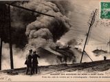 une vieille carte postale représentant deux hommes debout devant un feu d'où s'échappent des volutes de fumée