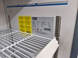 a white refrigerator with a yellow label on the door
