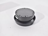 the top of a black knob is shown on a white surface