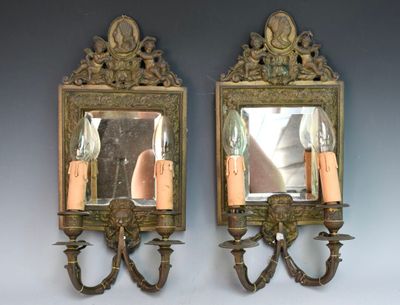 deux miroirs accrochés au mur, avec des bougies à l'intérieur