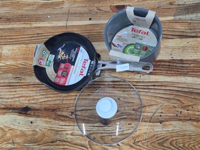 a frying pan and a frying pan sitting on a wooden table