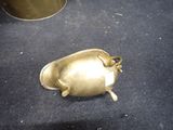 a small metal object on the floor next to a cup