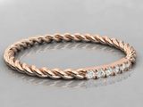 a rose gold ring with diamonds on a reflective surface