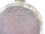 a close up of a gold colored clock with writing on it