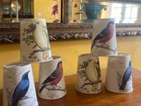 cinq tasses ornées d'oiseaux, posées sur une table