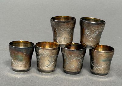 six coupes en argent ornées de motifs, posées sur une table