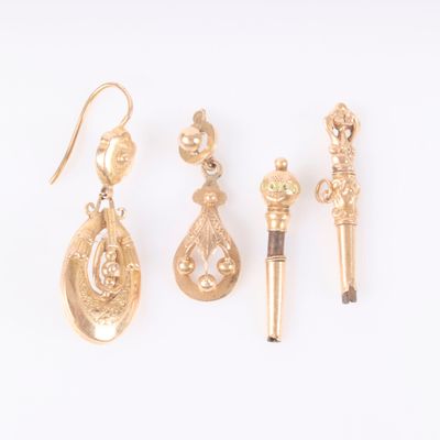 three pairs of gold earrings and a pen on a white surface