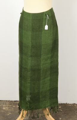 a green plaid skirt with fringes on a mannequin mannequin
