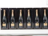 six bouteilles de champagne sont alignées sur une étagère